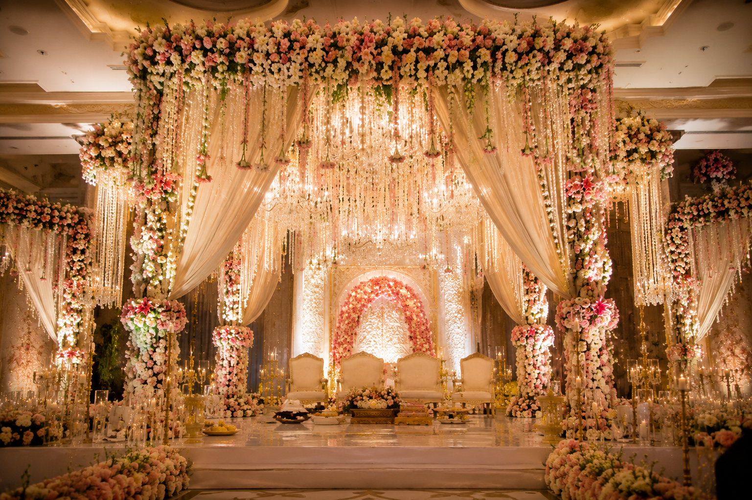Luxury wedding mandap decor with floral arrangements and chandeliers